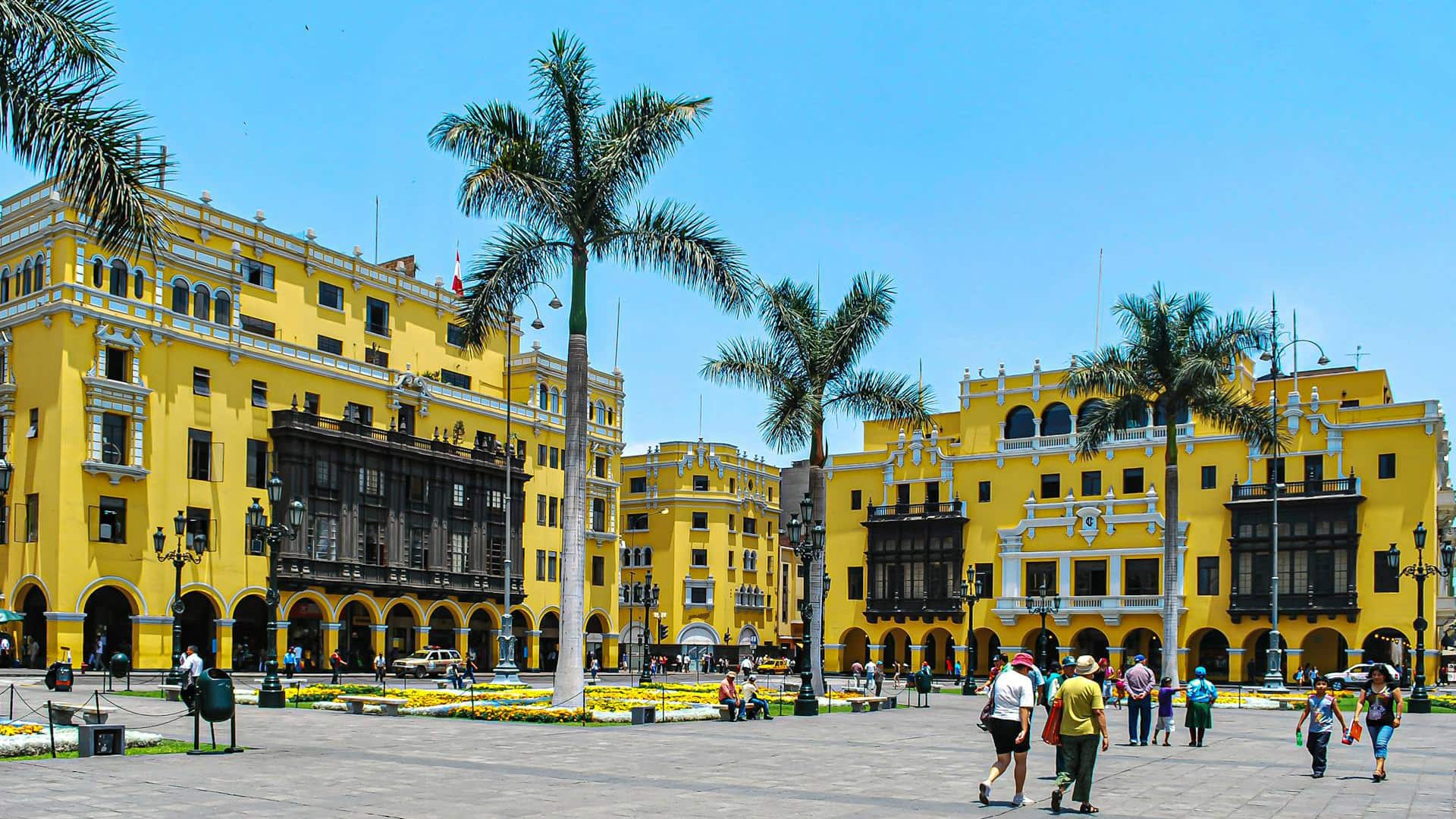 Plaza Mayor, Lima, Peru: A vibrant yellow colonial square under a bright blue sky, featuring palm trees, ornate architecture.